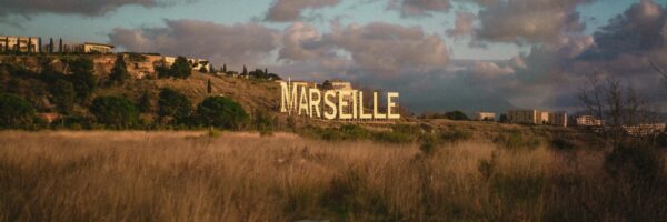 white and brown wooden house on green grass field under gray clouds
